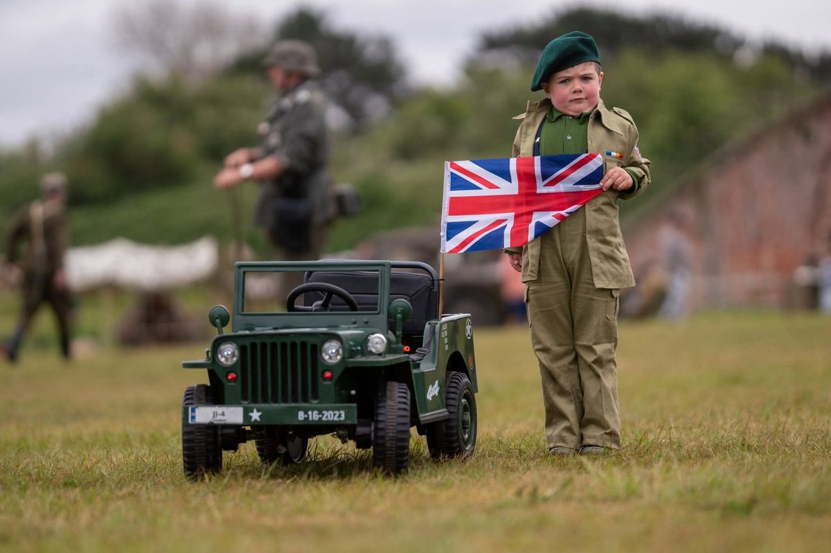 A child dressed in military uniform holds a union jack flag at Fort Paull Battery Heritage Site, Holderness