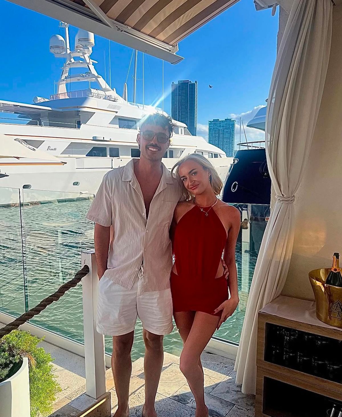 Shona and George on a harbour with a yacht in the background