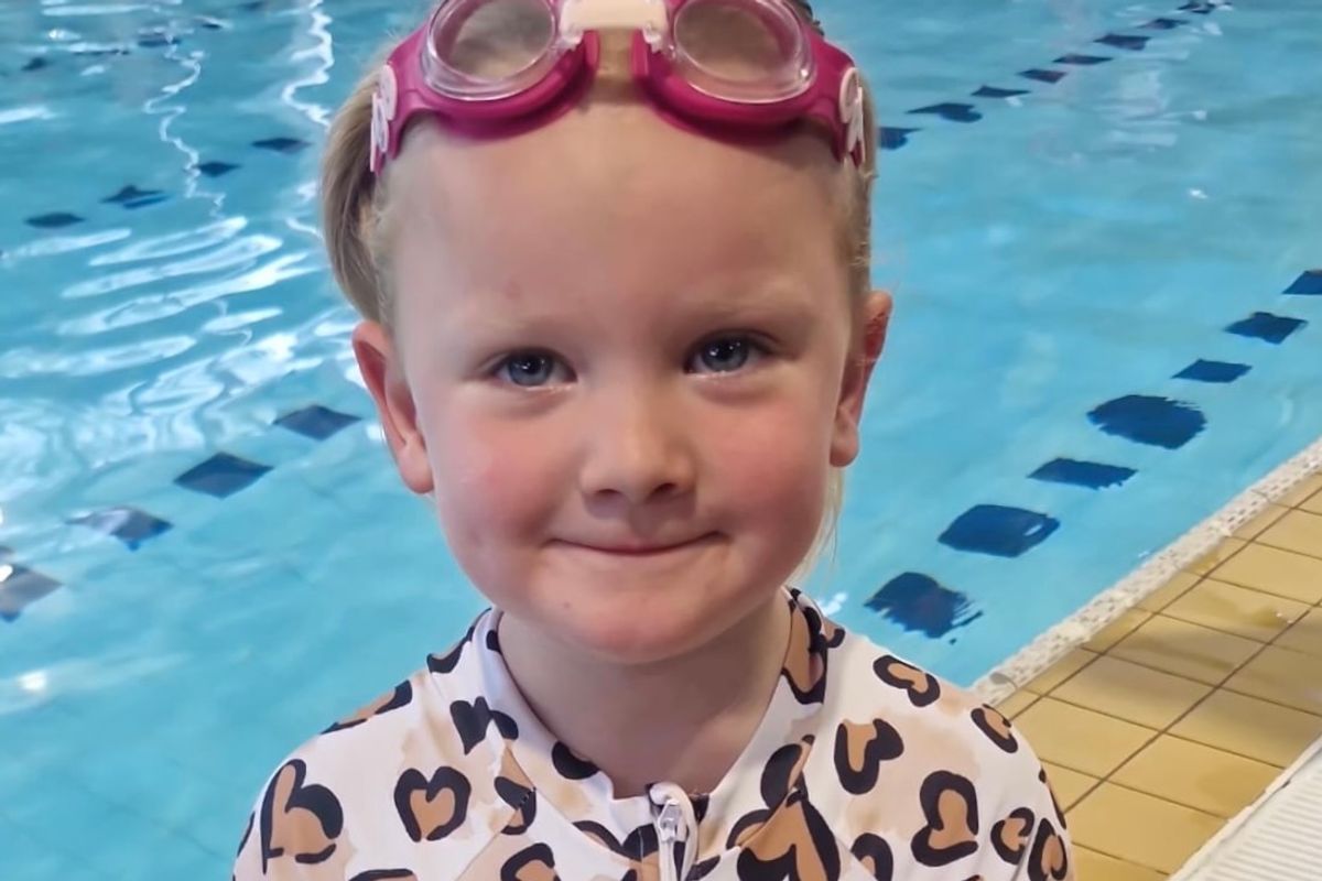 Skyla, 3, poolside with her swimming certificate after completing 10 continuous metres