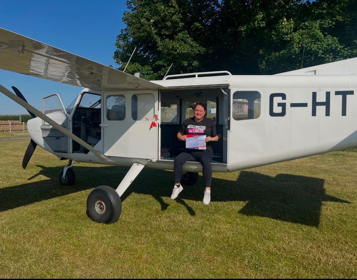 Paula sits in the plane with her certificate
