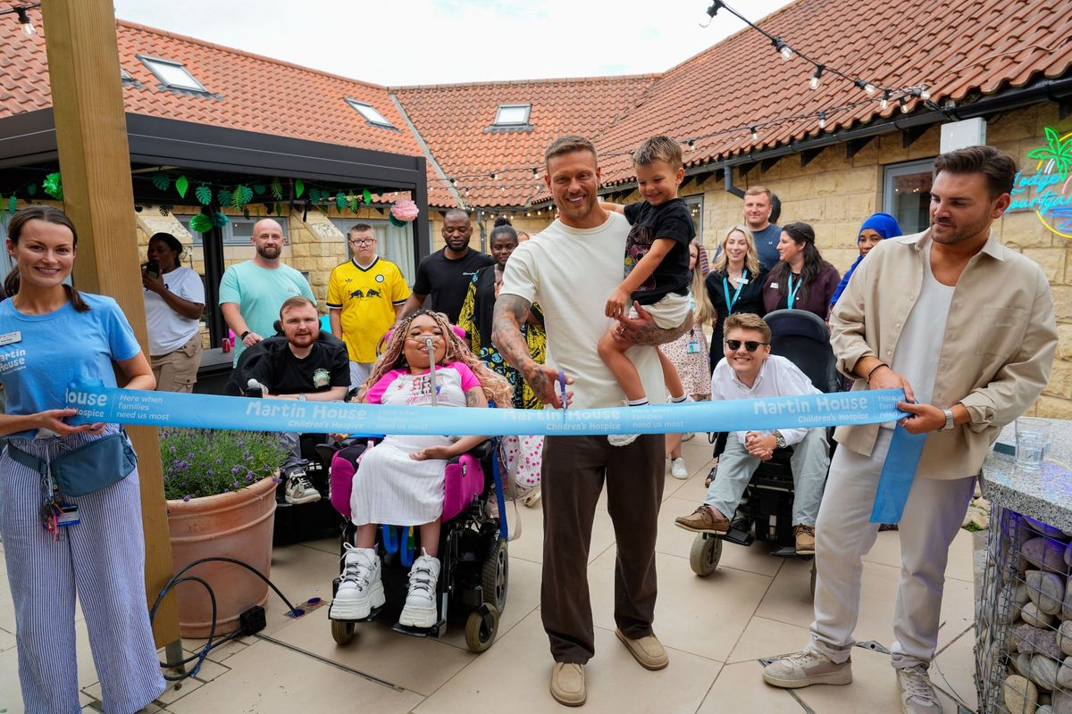 Love Island's Alex Bowen and his son Abel perform the ribbon-cutting at Martin House