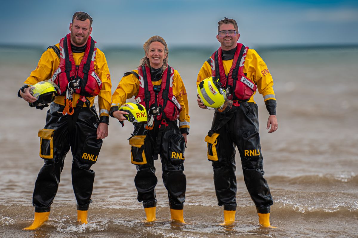 The volunteer RNLI crew that assisted the paddleboarders on Saturday standing in the sea