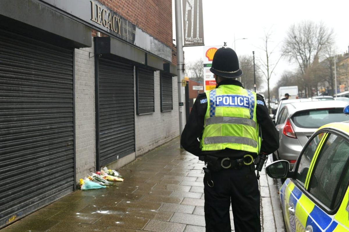A police officers guards the Hessle Road branch of Legacy Independent Funeral Directors, Hull, where flowers have been laid.
