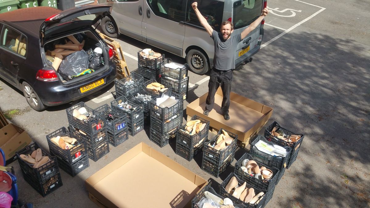 STAND director Phil after a collection run in 2020 surrounded by prosthetic feet and other parts of prosthetic legs
